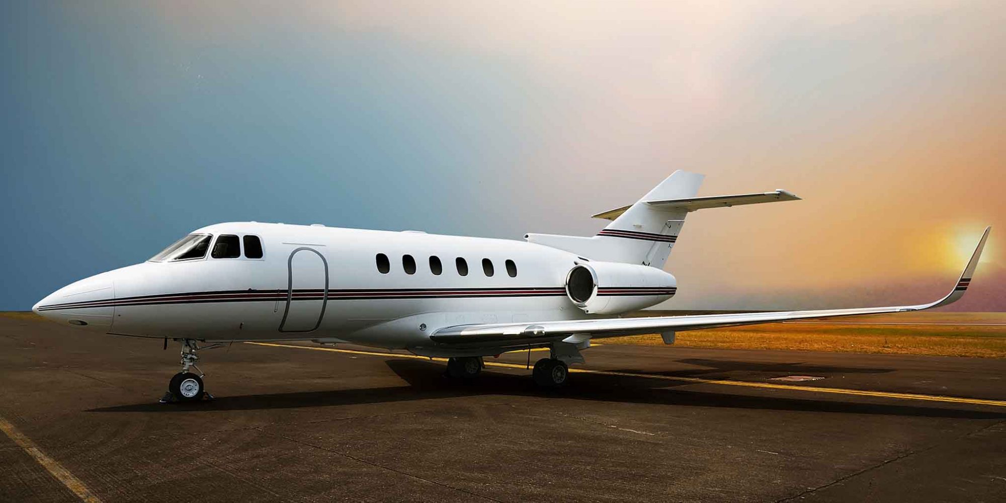 Private jet airplane parking at the airport. With sunset background