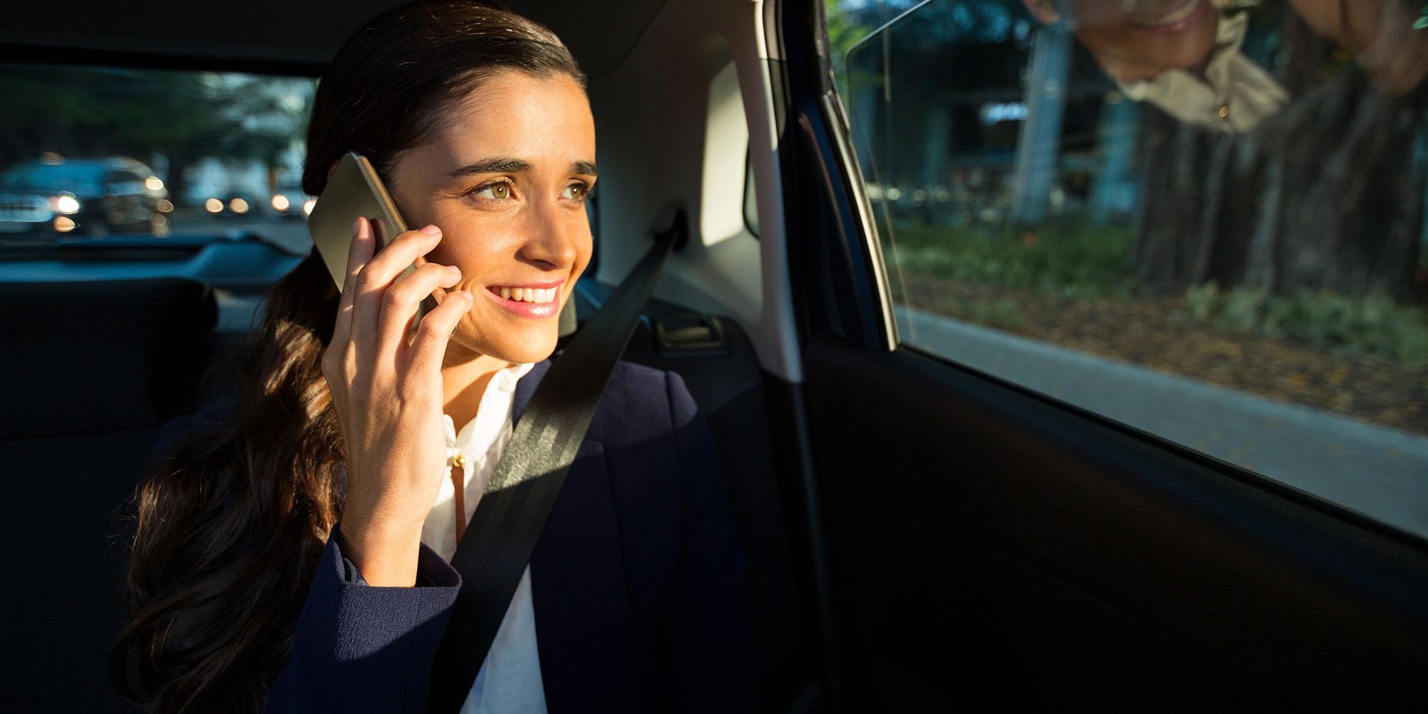 business-executive-talking-on-mobile-phone-in-car-A9M4VDN
