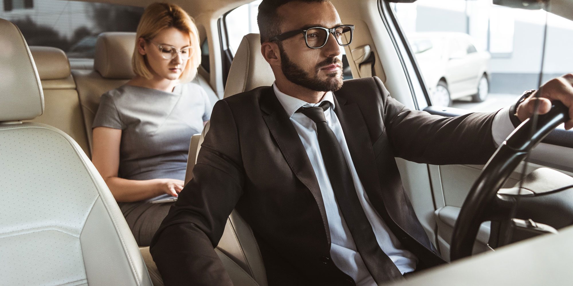 handsome-driver-and-attractive-businesswoman-in-ca-TKJCTHJ